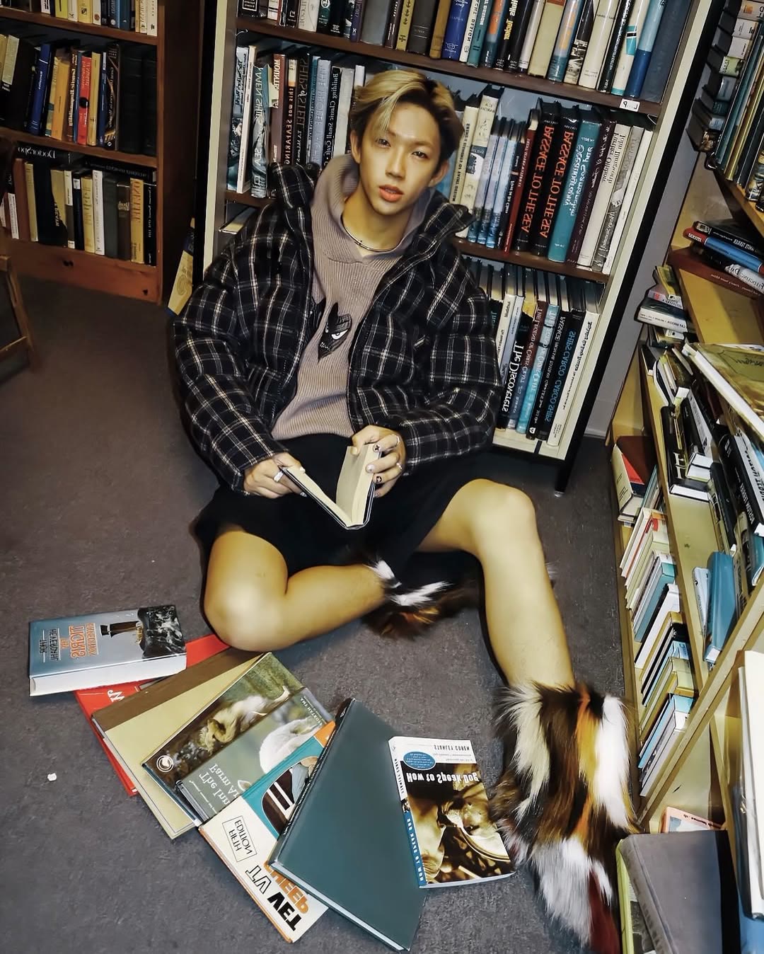 Fashion portrait seated on the bookshop floor among scattered books