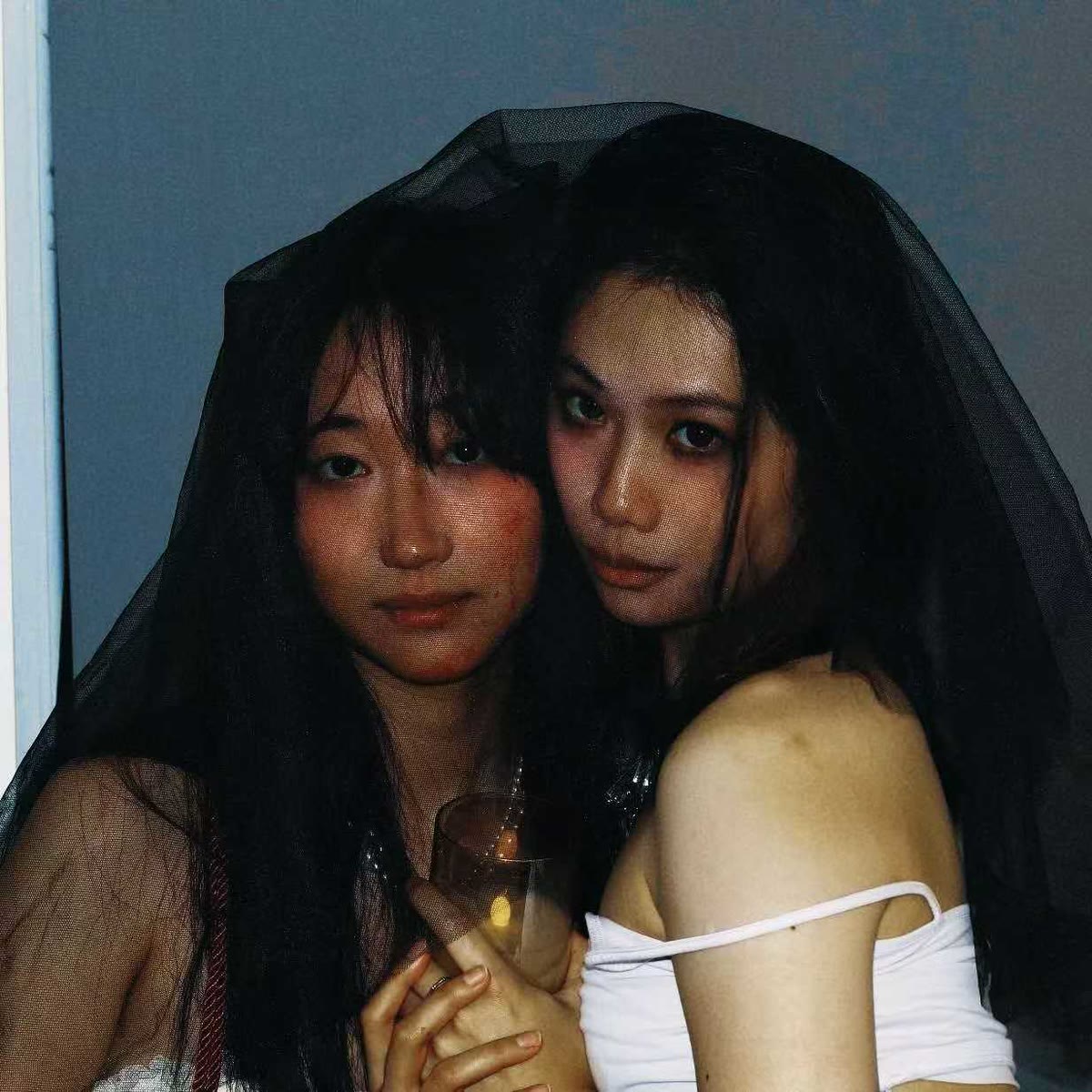 Ottawa sapphic couple looking through a dark veil in a direct-flash portrait